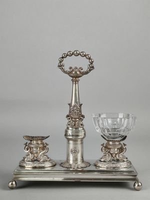 a silver plate with a glass on top of it