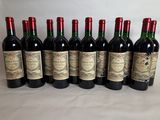 six bottles of red wine lined up in a row