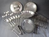 a lot of silverware on a table with a silver spoon and fork