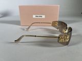 gold rimmed sunglasses with pink box on white surface