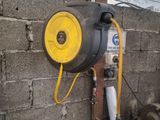 un tuyau jaune fixé au mur, à côté d'un mur de briques