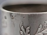 a close up of a silver cup with a design on it