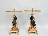 paire de bougeoirs anciens en bronze et en verre, représentant un homme et une femme sur un socle