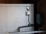 une porte métallique sur laquelle est fixé un compteur, dans un immeuble