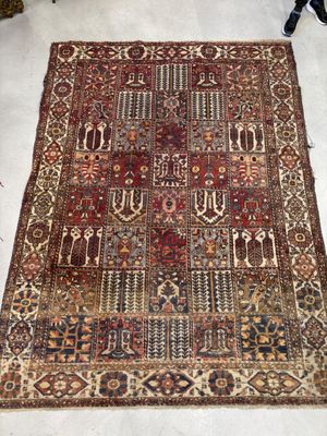un tapis persan ancien posé au sol dans un salon