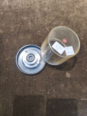 un verre d'eau posé par terre à côté d'une bouteille