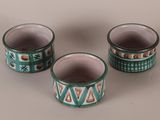 three green and white cups sitting on top of a table