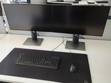 a computer desk with two monitors and a keyboard on it