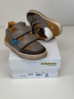 une boîte sur laquelle est posée une paire de chaussures de bébé