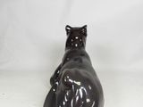 brown cat figurine sitting on a white surface with a white background