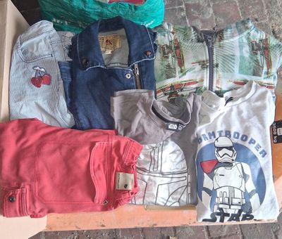 a box full of t - shirts and other items on the floor