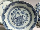 three blue and white plates sitting on top of a white table