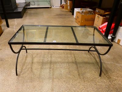une table basse en verre avec une structure en métal et un plateau en verre