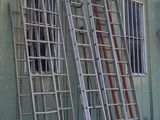 many ladders leaning against the side of a building