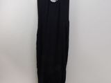 a black dress hanging on a hanger in front of a white wall
