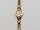 an image of a gold wrist watch with a chain around it