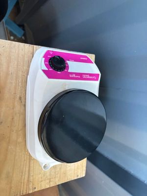 un bouton rose sur le côté d'une table en bois
