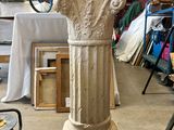 a white pedestal with a bird on top of it