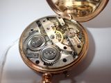 a close up of a pocket watch on a white surface