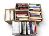 une boîte remplie de livres posée sur une surface blanche