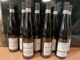 six bouteilles de vin sont alignées sur une table en bois