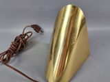 a gold metal cone with a cord attached to it