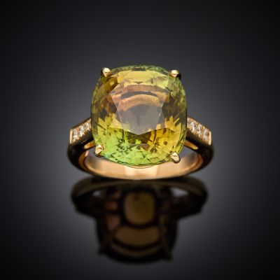 an image of a yellow and green ring with diamonds on a black surface