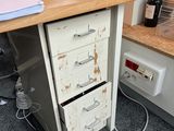 a desk with a file cabinet and a laptop on it