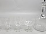 several empty wine glasses and a bottle on a white surface