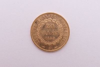 gros plan d'une pièce d'or sur une surface blanche
