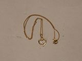 a close up of a gold necklace with a heart on it