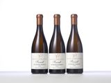 three bottles of wine are lined up on a table