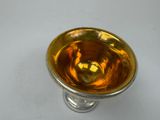 a silver and gold glass vase sitting on a white table