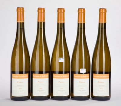quatre bouteilles de vin sont alignées sur une surface blanche