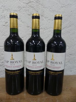 trois bouteilles de vin posées sur une table en bois