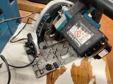 someone is using a circular saw to cut a piece of wood