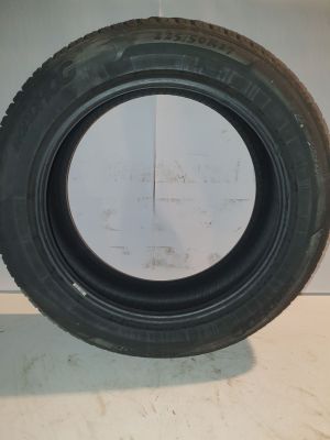 tire of a car on a white surface with a white wall in the background