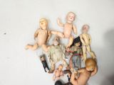 a person holding a bunch of dolls in their hands