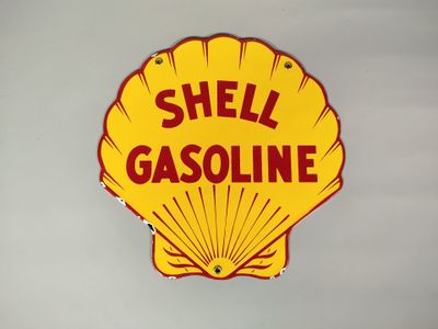 panneau « Shell » jaune avec des lettres rouges sur un mur blanc