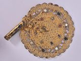gold plated brooch with a lion head on it and a red stone in the center