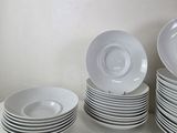 a lot of white plates stacked on top of each other