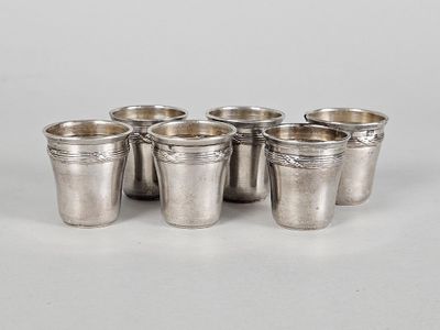 a set of six silver cups on a white surface