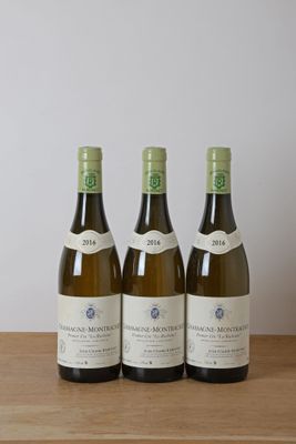trois bouteilles de vin posées sur une table en bois