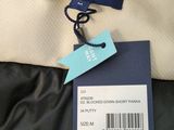 a close up of a black and white jacket with a tag on it
