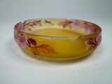 a yellow bowl with pink flowers on it on a white surface
