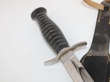 a knife that is laying on top of a leather case