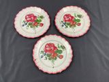three plates with red flowers on them sitting on a table