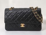 un sac à bandoulière Chanel en cuir matelassé noir, avec des finitions dorées