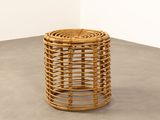 a wicker stool that is sitting on a cement floor