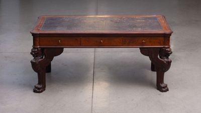 a wooden table with a glass top on a cement floor